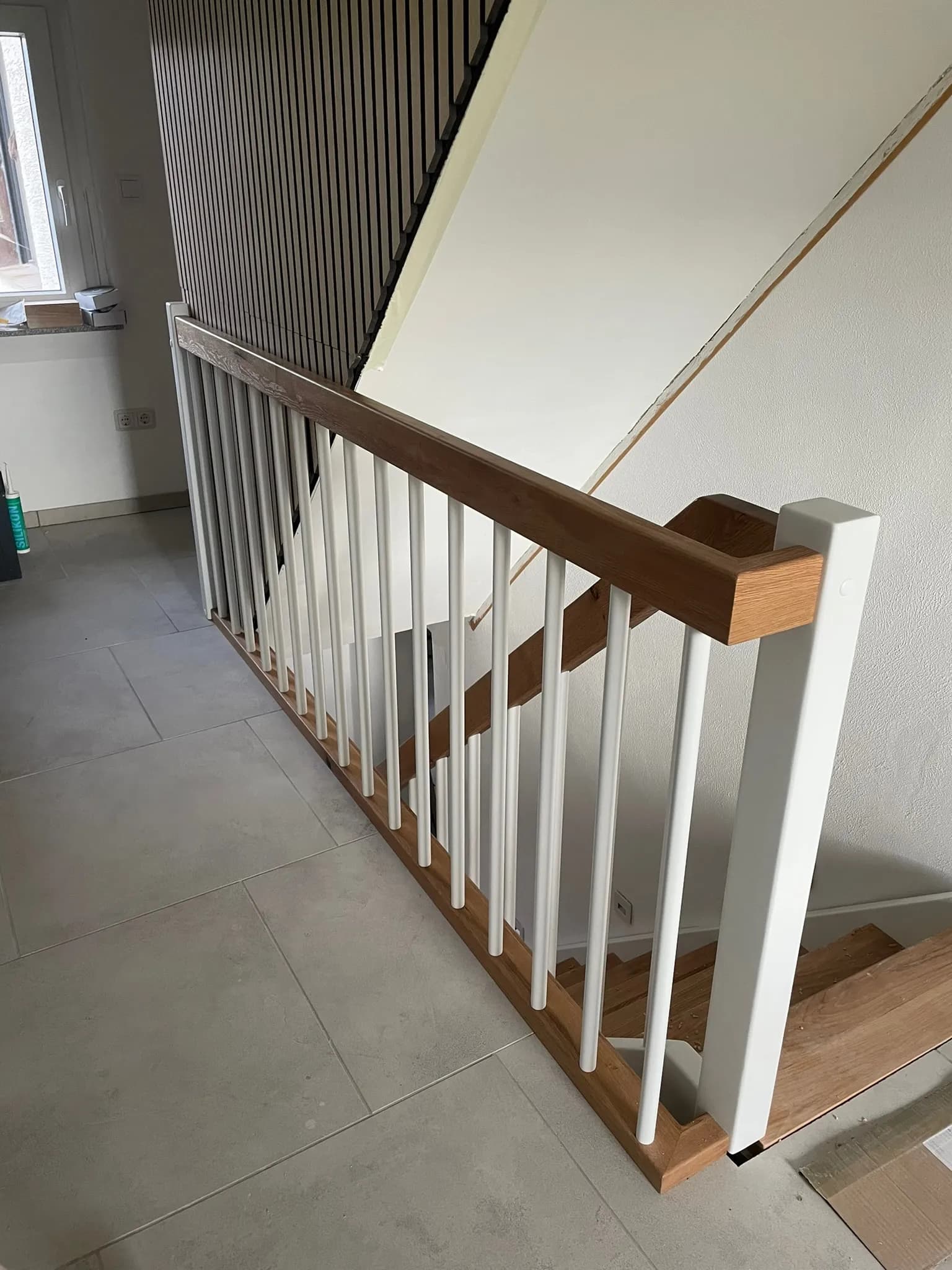 Treppengeländer mit Eichenhandlauf und weißen Metallstäben an der Galeriebrüstung eines HTS-Projekts in Kamen