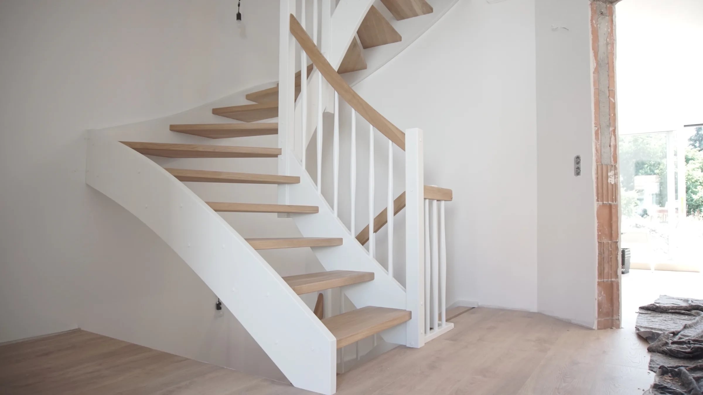 Stringer staircase in oak with white stringers, posts, handrail and balusters — manufactured in our Witten workshop