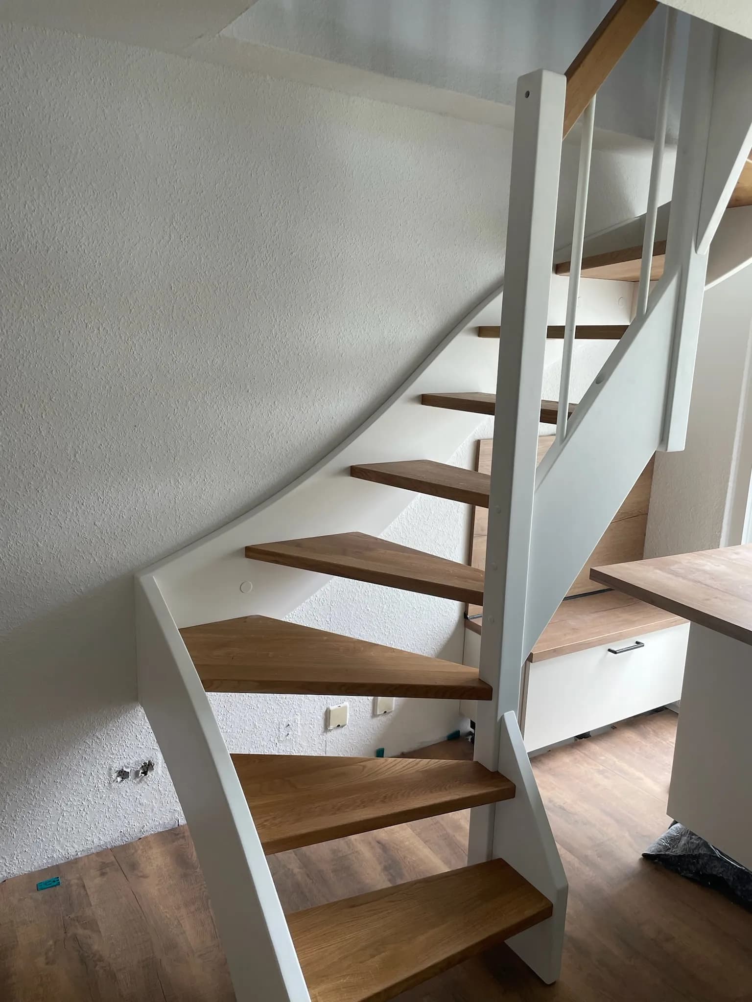 Halbgewendelte Wangentreppe von HTS mit weiß lackierten Wangen, Eichen-Trittstufen und Eichenhandlauf, Wohnhaus in Hagen
