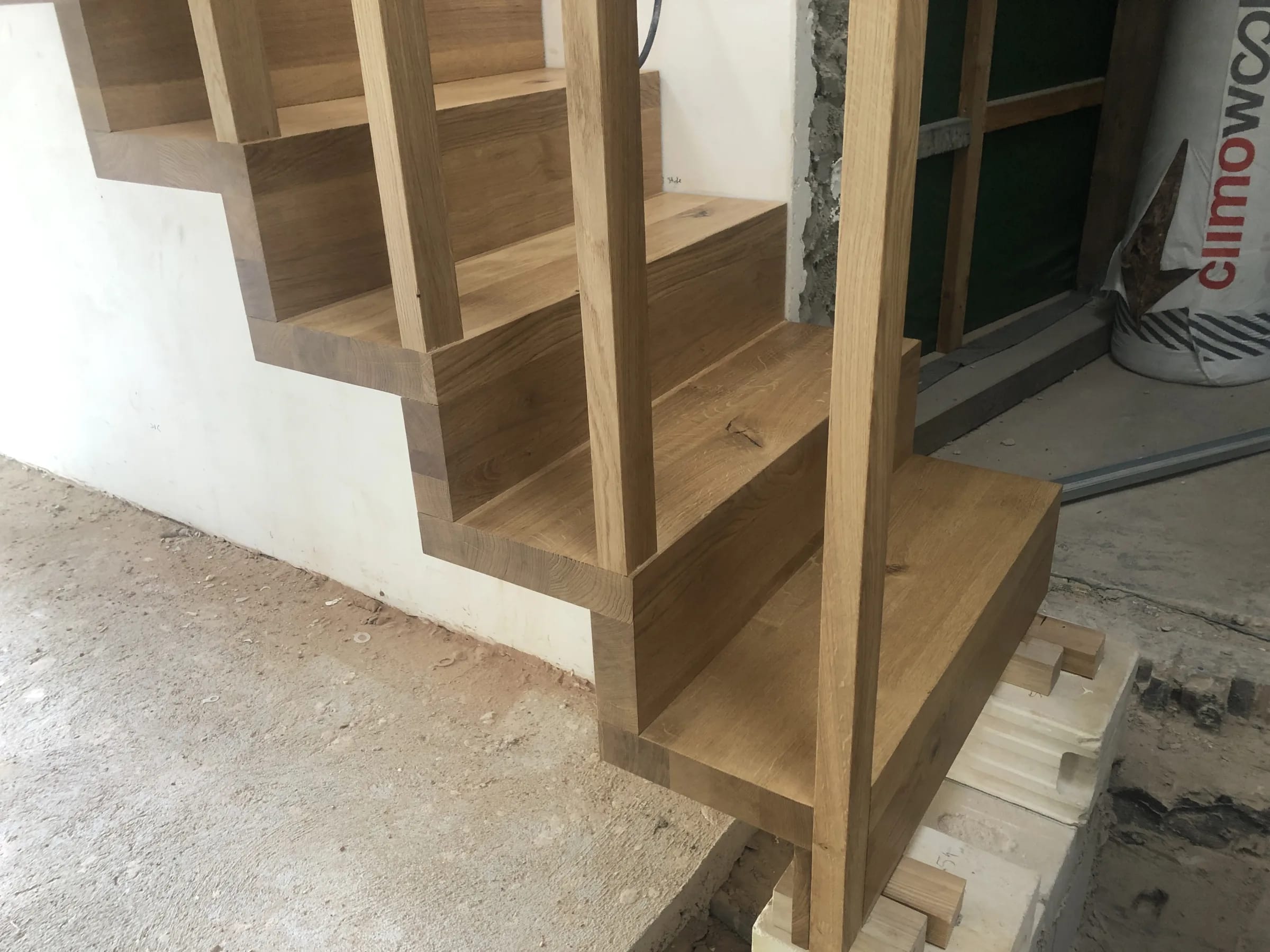 Free-standing folded staircase in oak with oak posts, handrail and balusters — example project from the Ruhr area