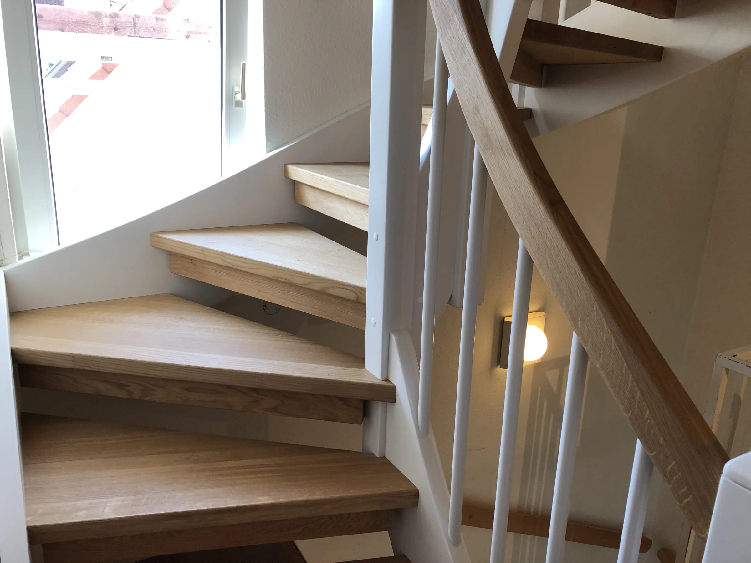 Stringer staircase with oak treads, white stringers, oak posts, handrail and white risers — manufactured in our Witten workshop